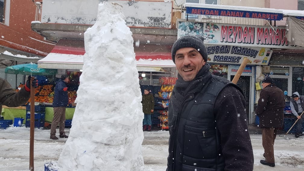 Hem dükkanlarının önünü temizlediler hem de kardan adam yaptılar